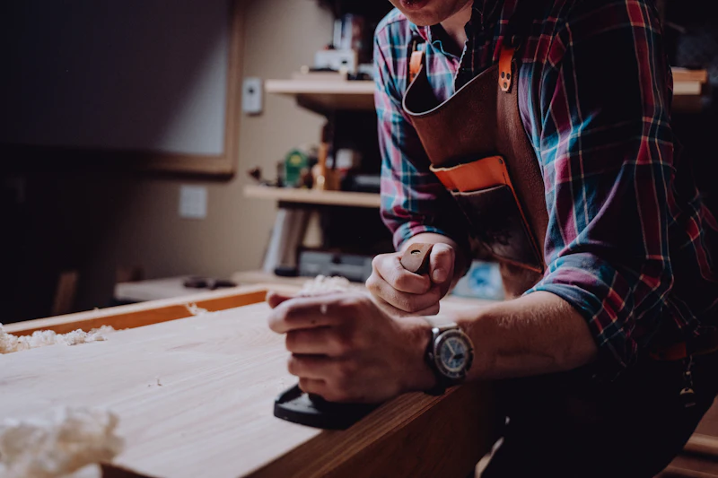 A woodworker finishing a board with a hand plane